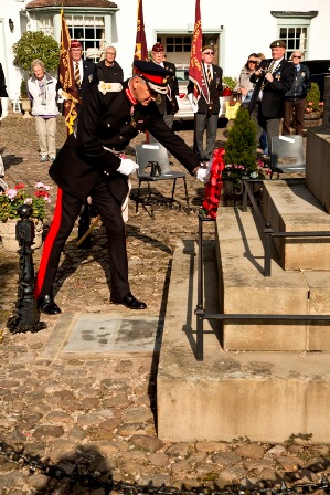 Placing a poppy wreath on the memorial statue